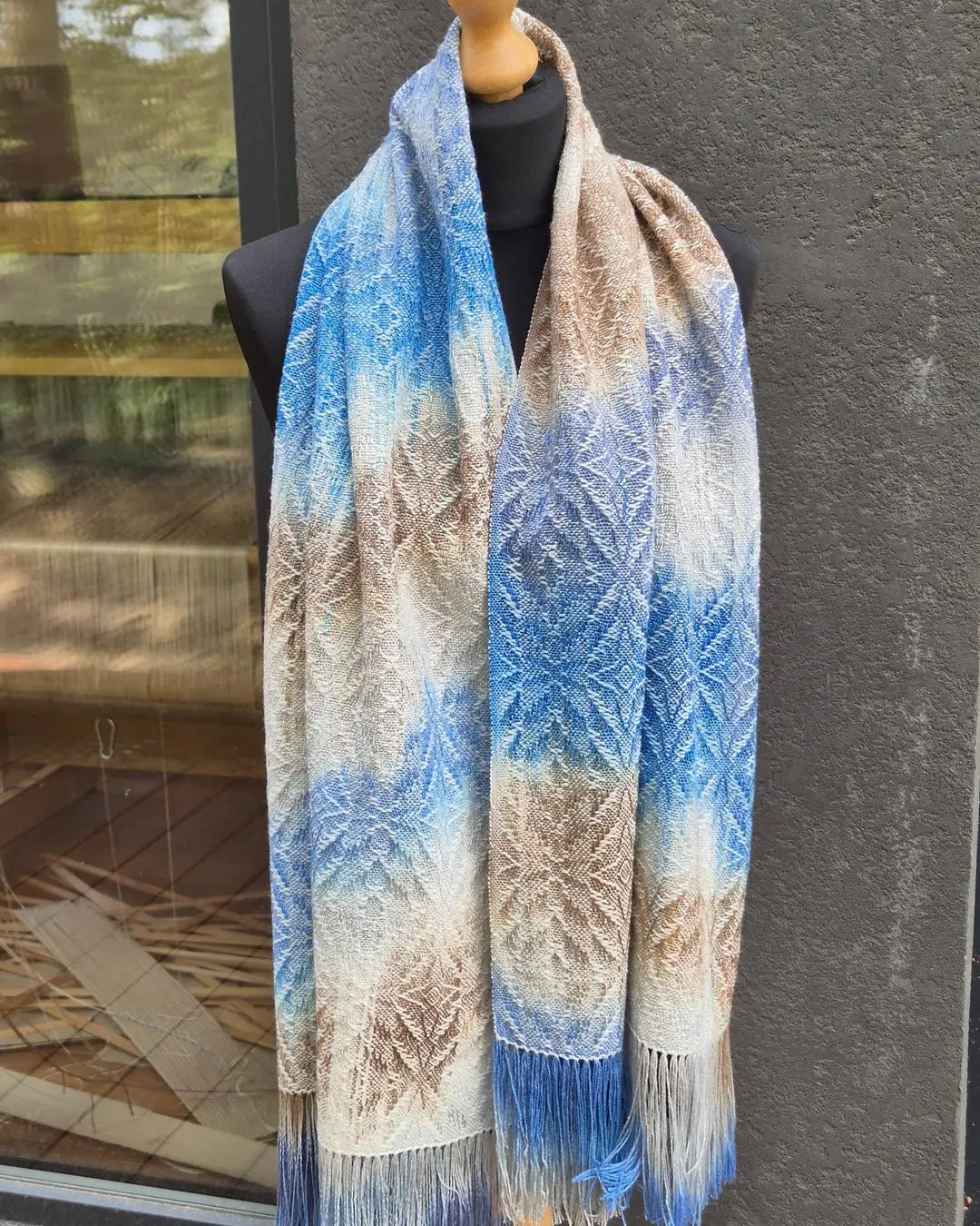Handwoven scarf in blue, beige and brown with fringes on a mannequin, made in a weaving course in Poland